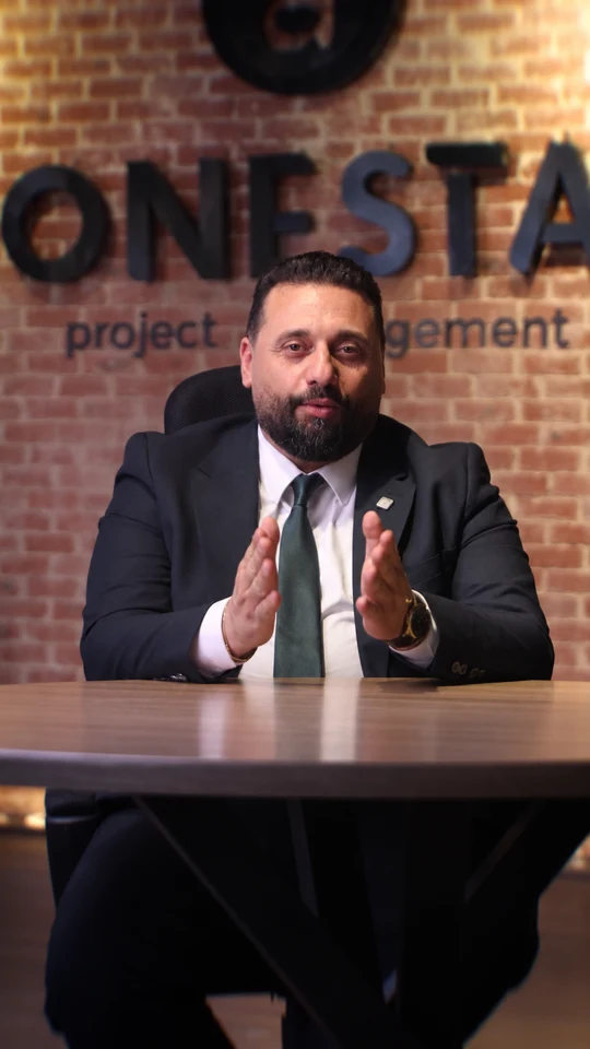 ONESTA representative seated at a desk in front of the company sign.